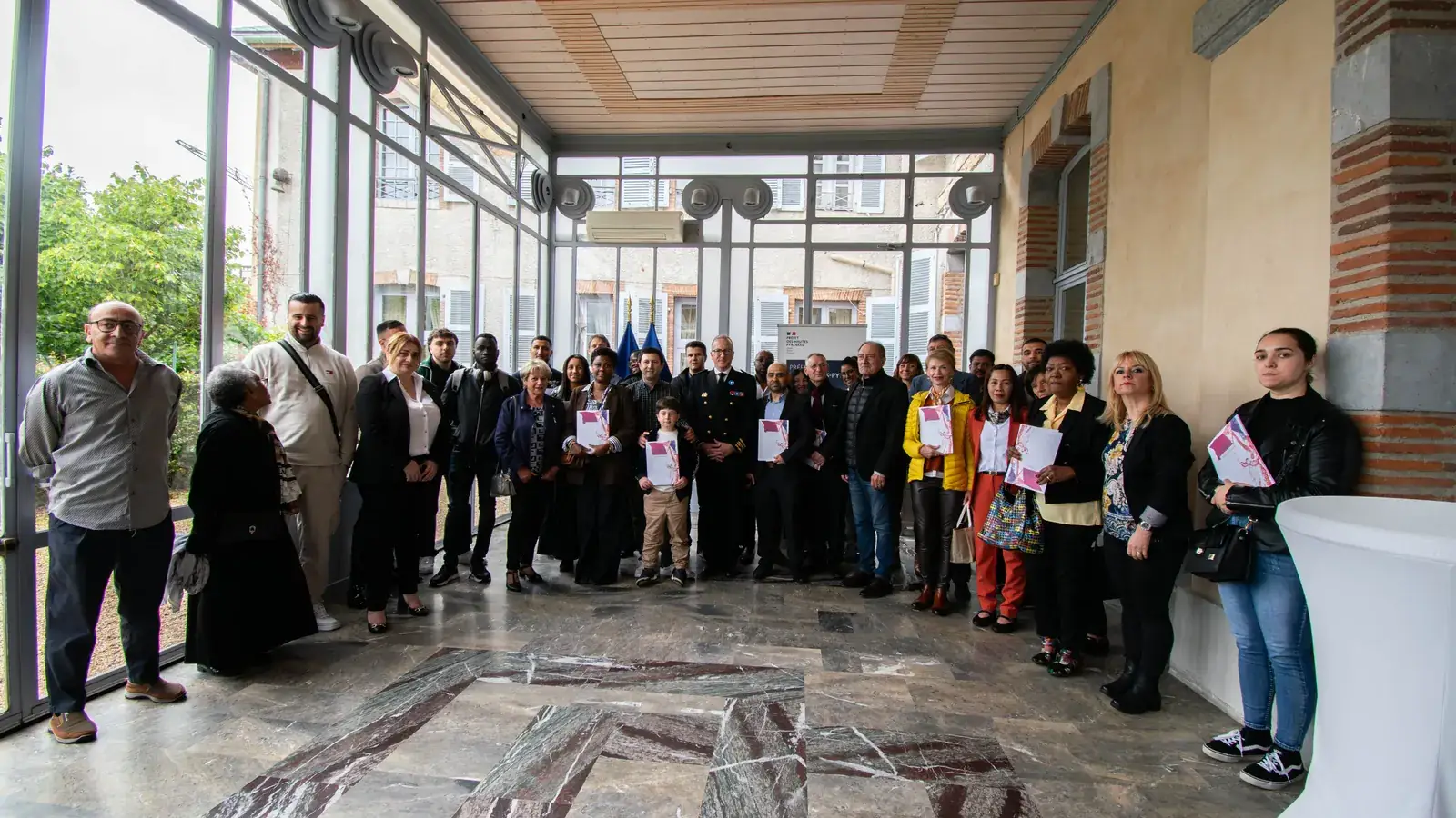 Cérémonie de naturalisation à la préfecture des Hautes-Pyrénées le 6 mai 2026 : 41 nouveaux Français reçoivent leur décret de naturalisation des mains du préfet, drapeau tricolore au fond